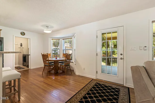 a kitchen with stainless steel appliances granite countertop a stove top oven a sink and dishwasher a refrigerator with wooden floor