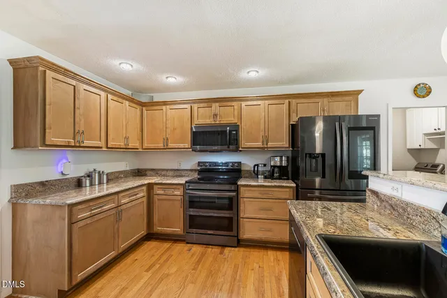 a kitchen with stainless steel appliances granite countertop a stove microwave and refrigerator