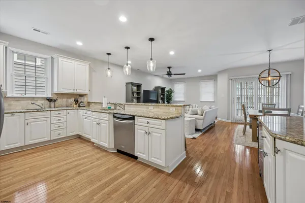 a large kitchen with white cabinets and stainless steel appliances