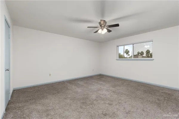 a view of an empty room and a ceiling fan