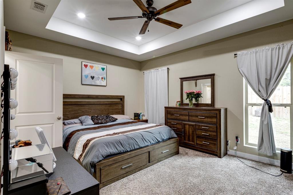 206 Willowbrook Avenue Tyler, TX 75702 - Photo 15 of 25 a bedroom with a bed and a chandelier