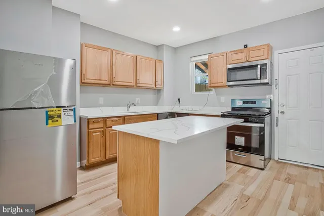 a kitchen with stainless steel appliances granite countertop a refrigerator and a stove top oven