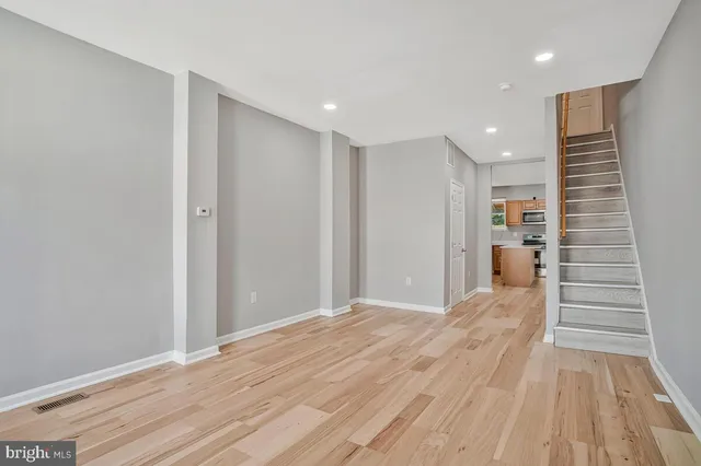 a view of a hallway with wooden floor and staircase