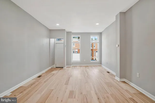 a view of an empty room with wooden floor
