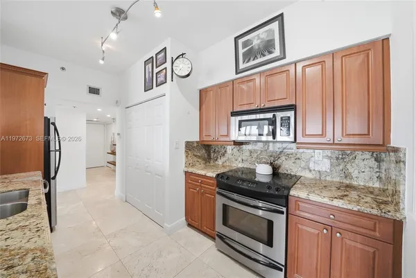 a kitchen with stainless steel appliances granite countertop a stove and a refrigerator