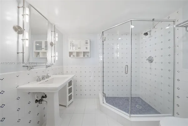 a bathroom with a shower sink and mirror