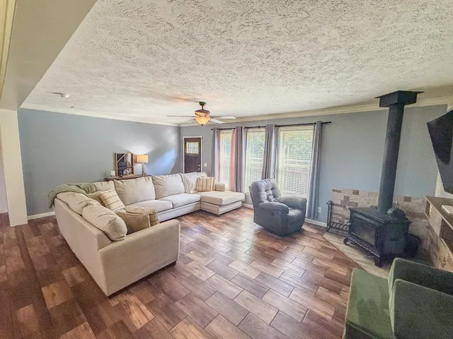 a large white kitchen with a large island oven a stove a sink and a wooden floor