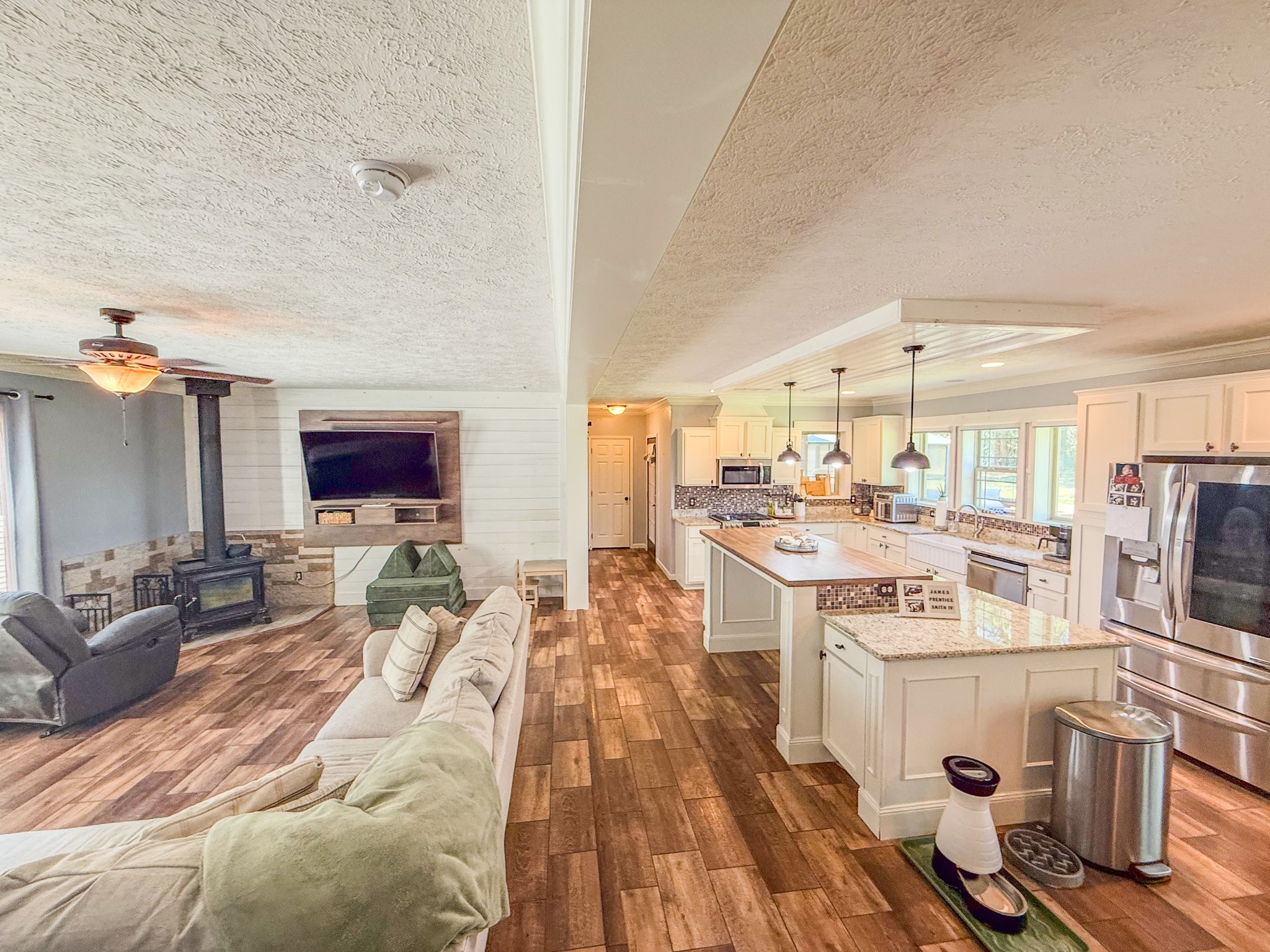 137 Hawkins Road Westmoreland, TN 37186 - Photo 25 of 70 a open kitchen with stainless steel appliances kitchen island granite countertop a stove top oven a sink dishwasher and a dining table with wooden floor