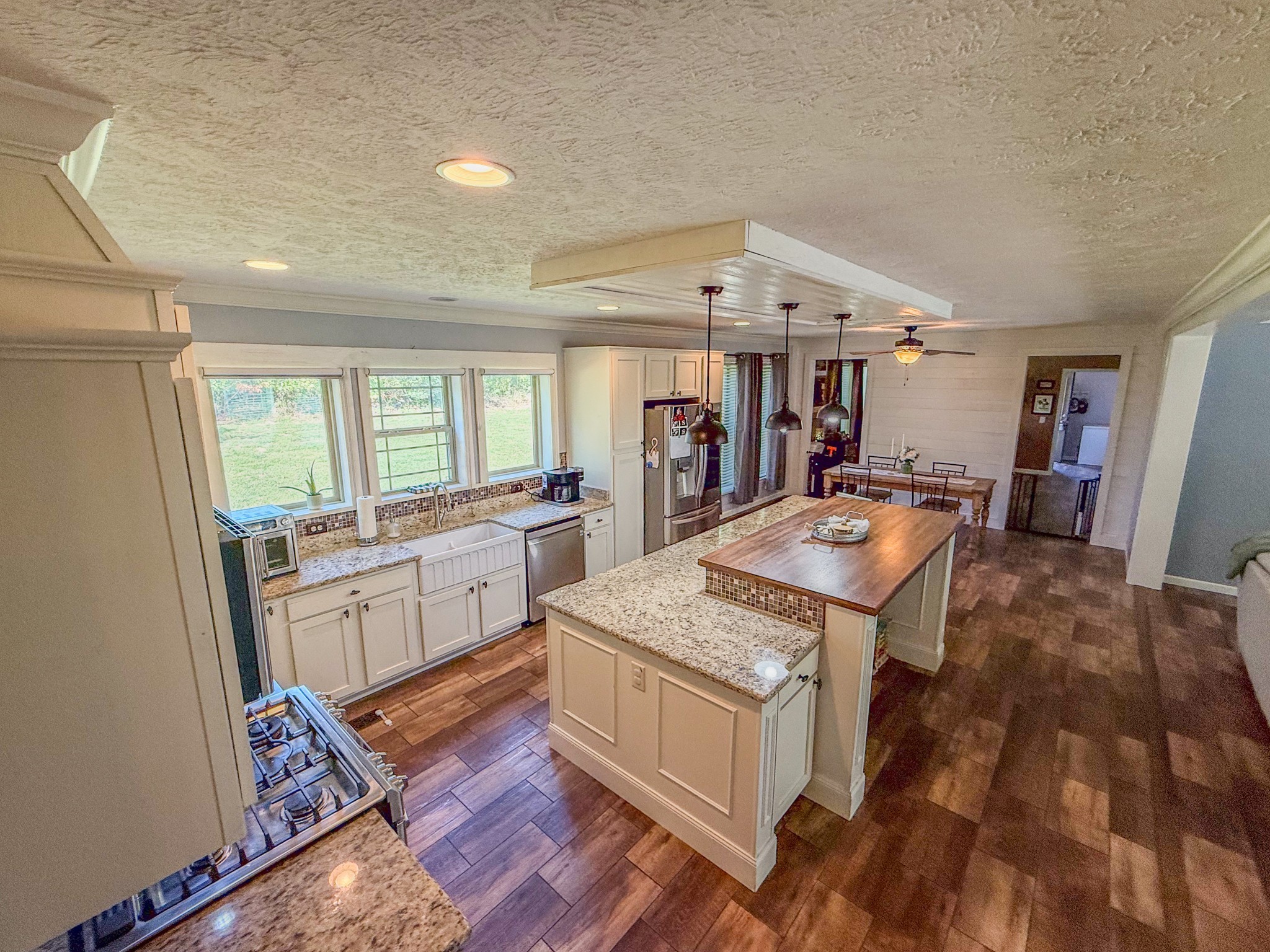 137 Hawkins Road Westmoreland, TN 37186 - Photo 27 of 70 a large kitchen with kitchen island a stove a sink dishwasher and white cabinets with wooden floor