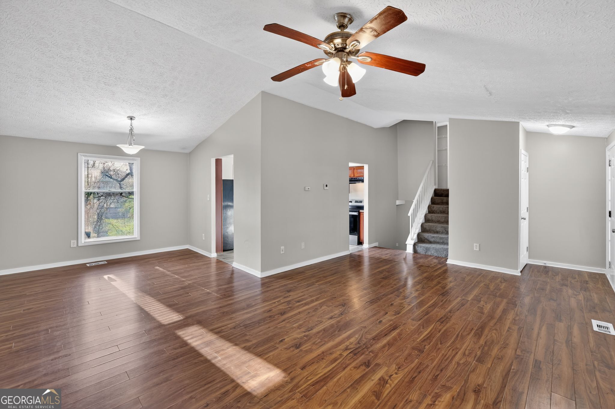 3798 Radcliffe Boulevard Decatur, GA 30034 - Photo 10 of 32 a view of an empty room with wooden floor and a ceiling fan