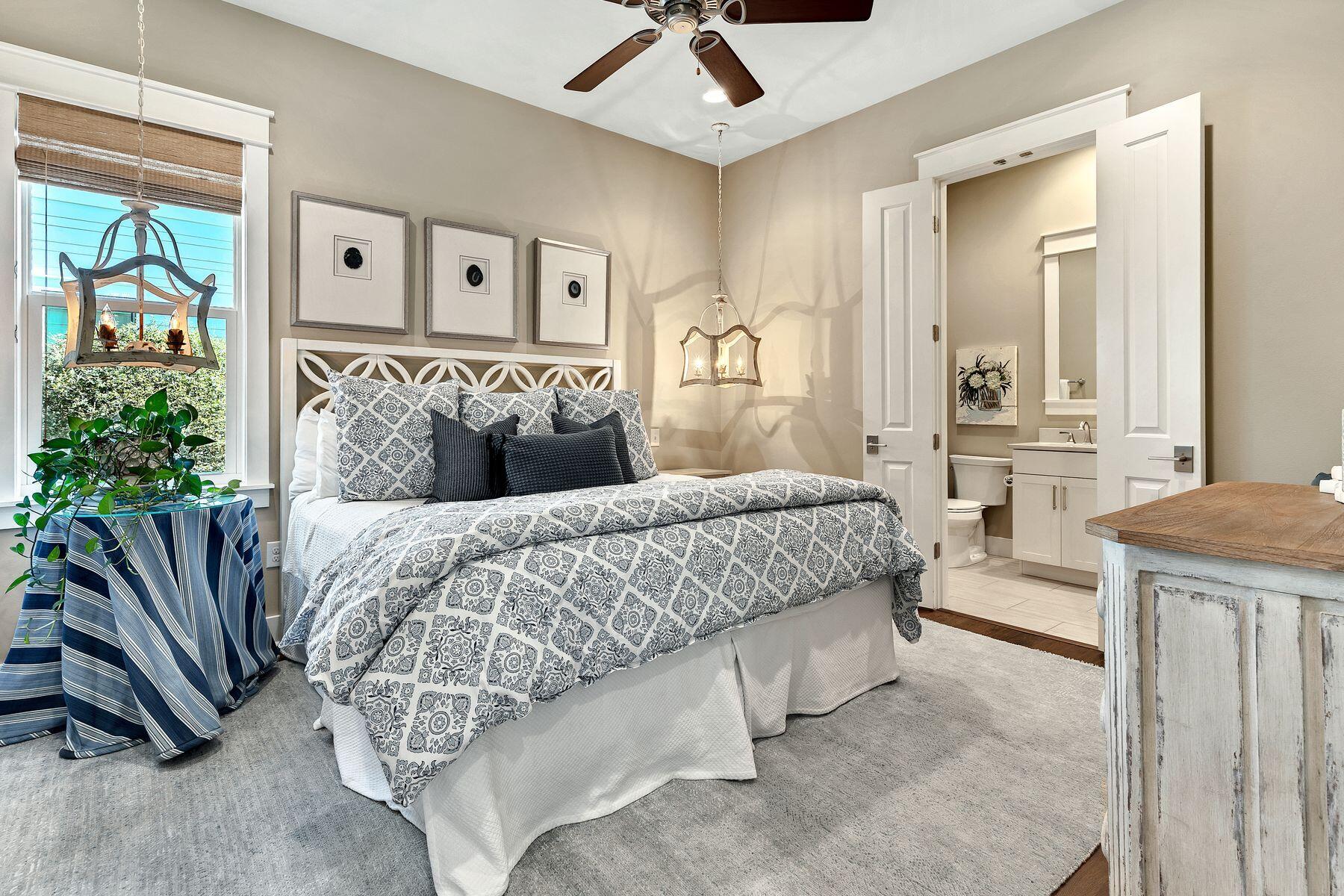 150 Medley Street Watersound, FL 32461 - Photo 17 of 30 a bedroom with a large bed and a chandelier