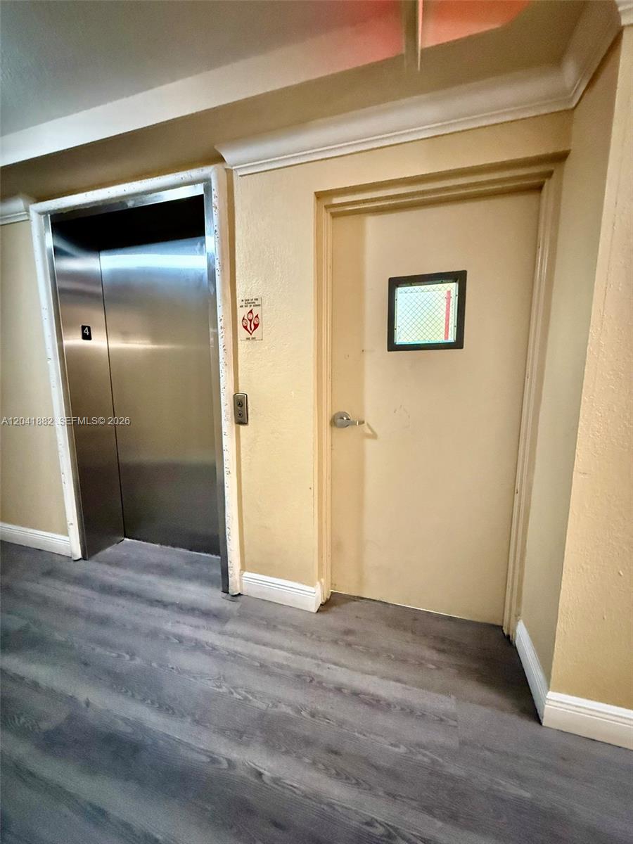 2475 Northwest 16th St Road, Unit 418 Miami, FL 33125 - Photo 22 of 27 a view of an empty room with wooden floor
