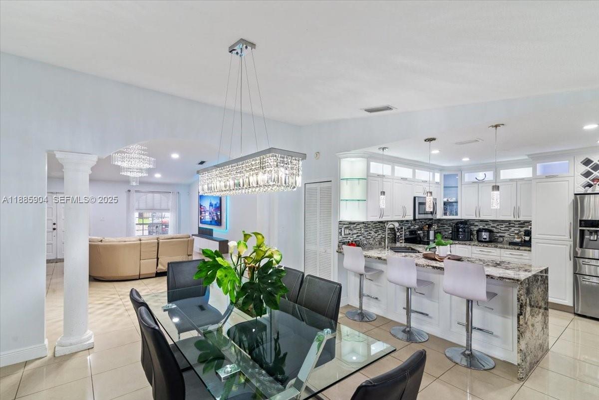 14500 Southwest 173rd Street Miami, FL 33177 - Photo 14 of 47 a living room with kitchen island furniture and a kitchen view