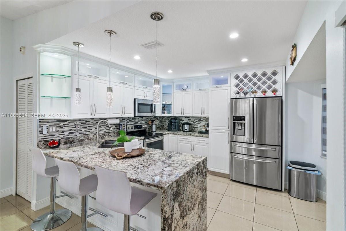 14500 Southwest 173rd Street Miami, FL 33177 - Photo 16 of 47 a kitchen with stainless steel appliances kitchen island granite countertop a refrigerator and a stove top oven