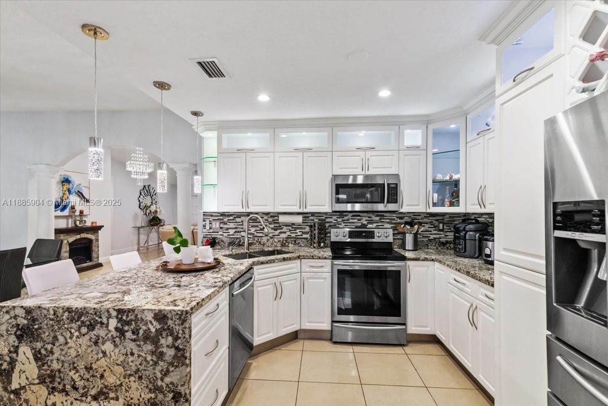 14500 Southwest 173rd Street Miami, FL 33177 - Photo 17 of 47 a kitchen with a sink a stove top oven and refrigerator