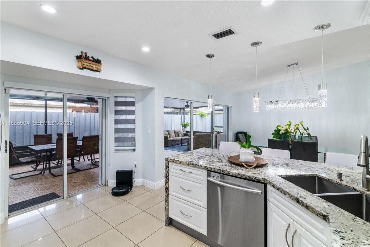 14500 Southwest 173rd Street Miami, FL 33177 - Photo 19 of 47 a kitchen with granite countertop a sink and cabinets