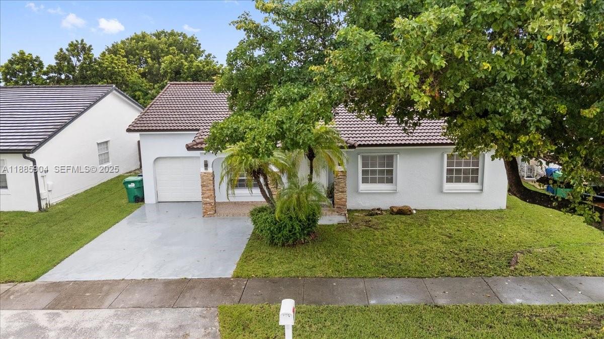 14500 Southwest 173rd Street Miami, FL 33177 - Photo 2 of 47 a front view of a house with a yard