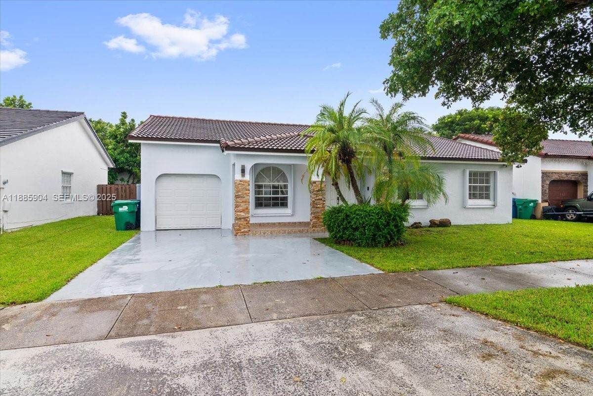 14500 Southwest 173rd Street Miami, FL 33177 - Photo 40 of 47 a front view of a house with a yard and garage