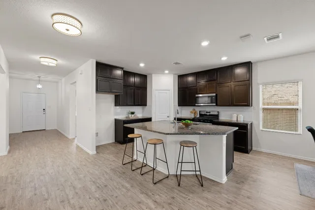 a kitchen with stainless steel appliances kitchen island granite countertop a sink and cabinets