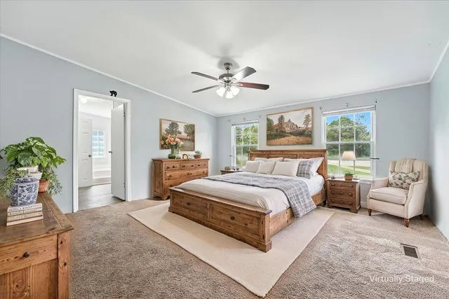 a spacious bedroom with a bed a couch and potted plant