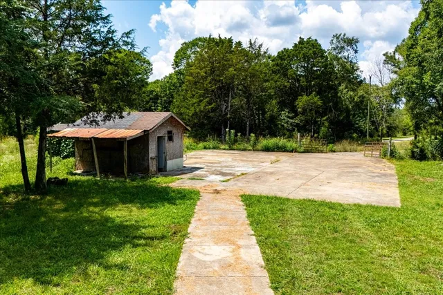 a front view of a house with a yard and trees