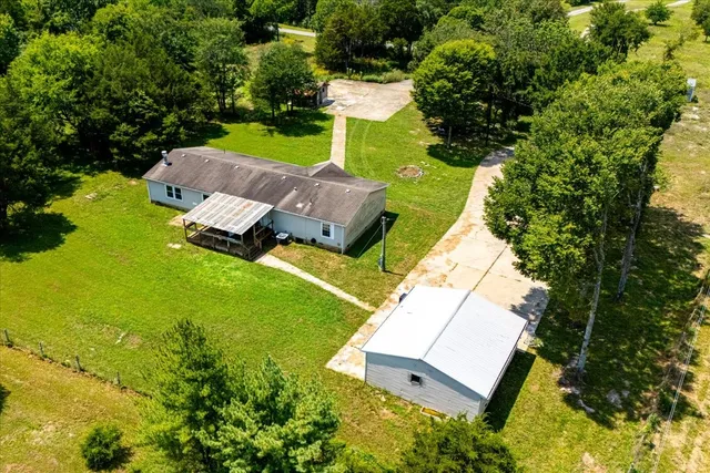 an aerial view of a house with swimming pool and garden