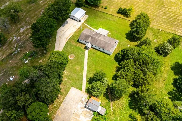 an aerial view of a house with a yard swimming pool and outdoor seating