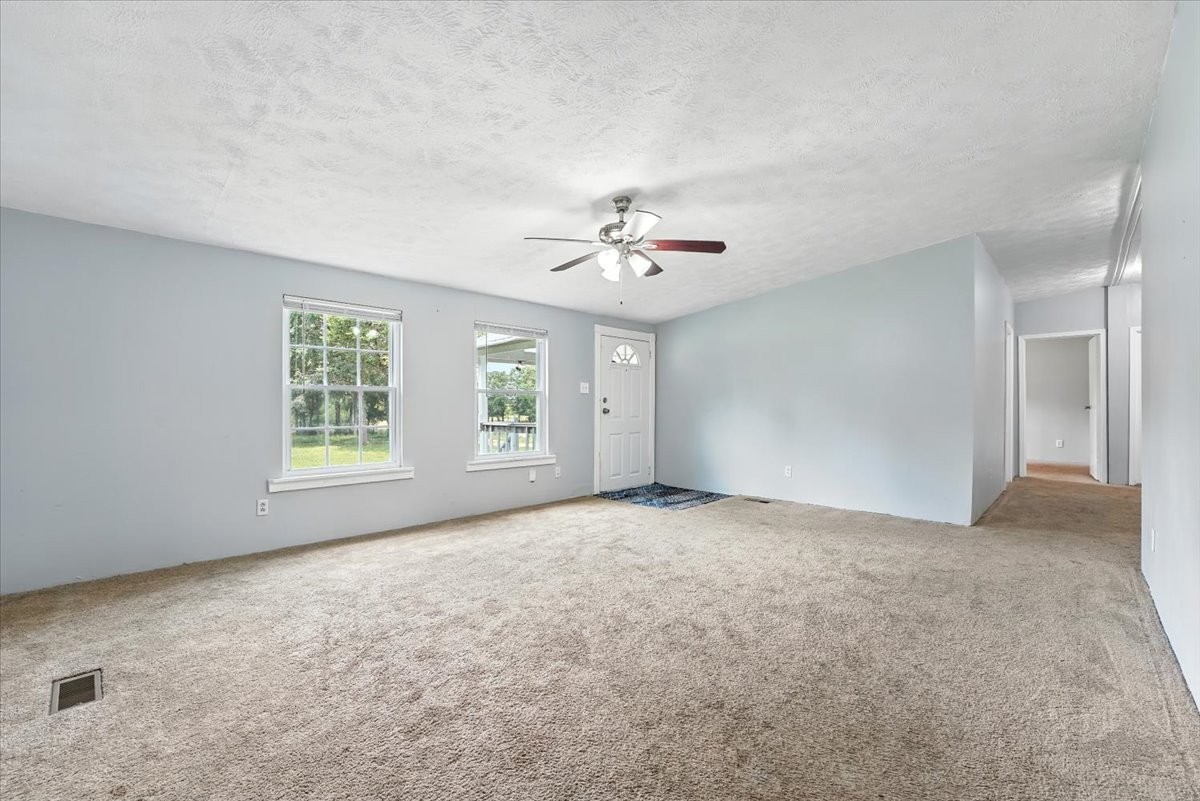 9484 Rocky Hill Road Lascassas, TN 37085 - Photo 8 of 38 an empty room with windows and ceiling fan