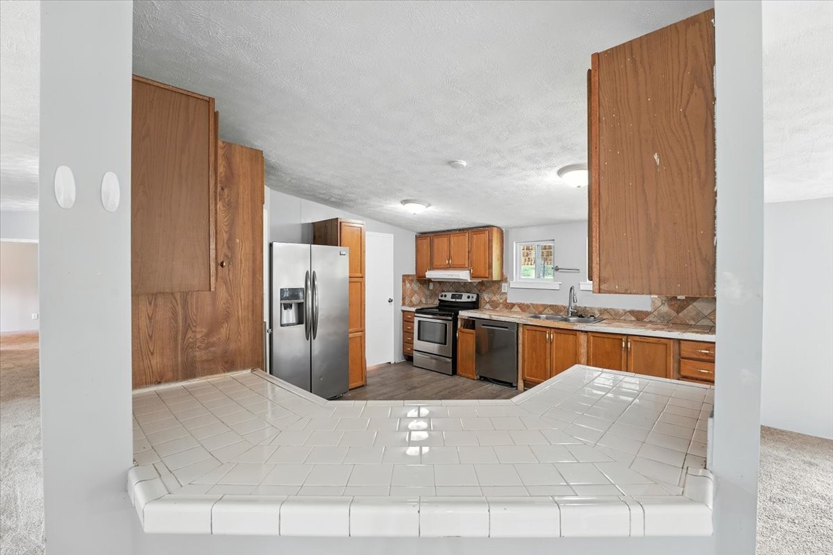 9484 Rocky Hill Road Lascassas, TN 37085 - Photo 9 of 38 a kitchen with stainless steel appliances kitchen island granite countertop a refrigerator and a sink