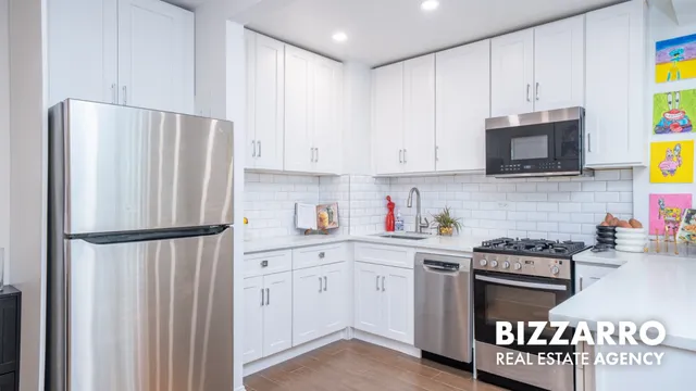 a kitchen with stainless steel appliances granite countertop a refrigerator a stove a sink and a window