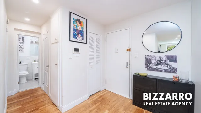 a kitchen that has a lot of white cabinets and stainless steel appliances