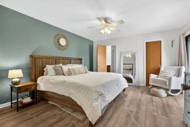 a spacious bedroom with a bed and a chandelier