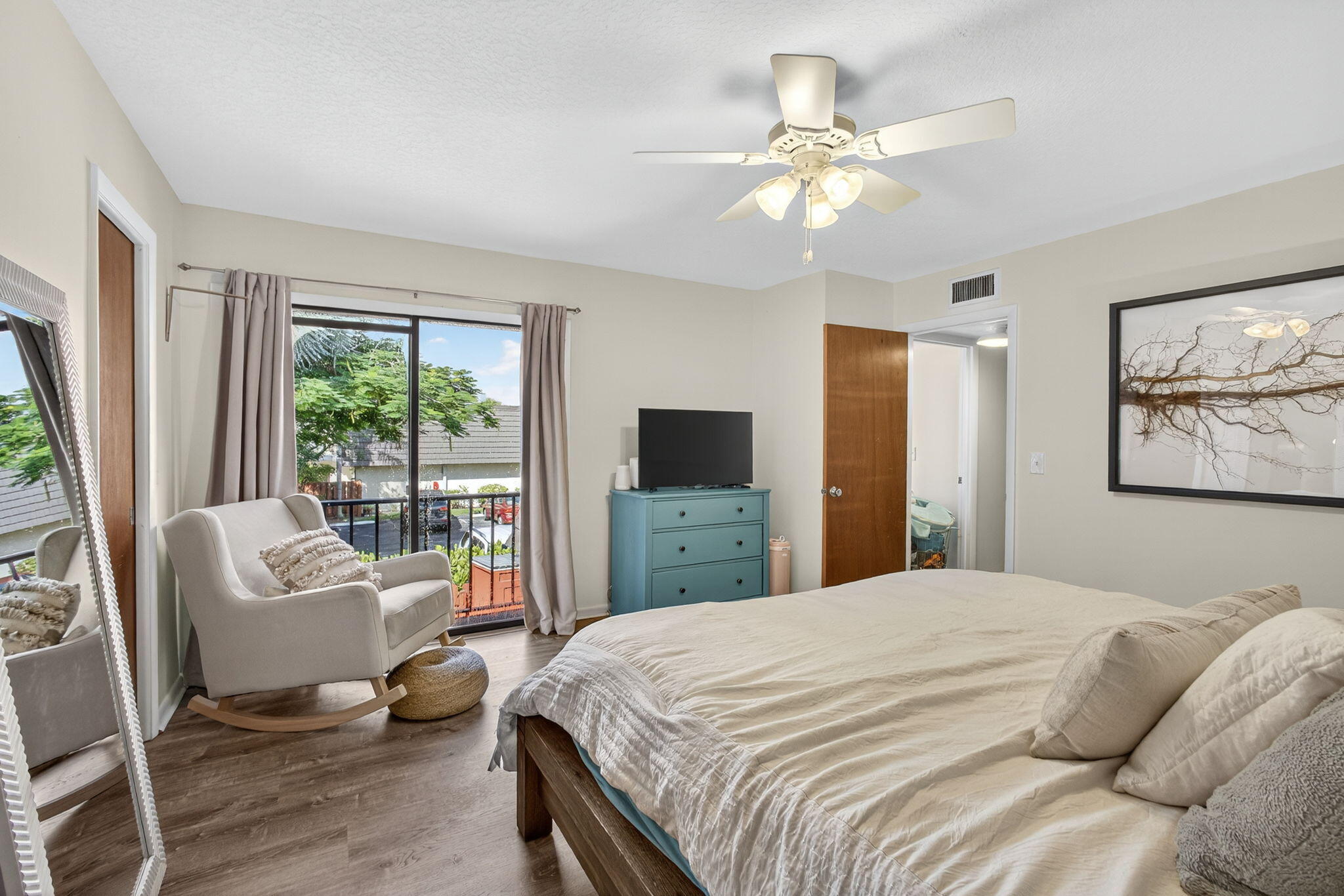 326 Jupiter Lakes Boulevard, Unit 2310C Jupiter, FL 33458 - Photo 33 of 46 a bedroom with a large bed a flat screen tv and a couch