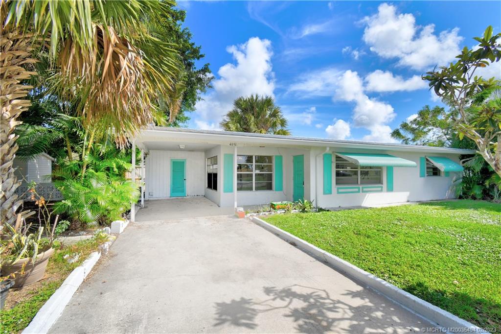 4651 Southeast Chatham Avenue Stuart, FL 34997 - Photo 1 of 49 a front view of a house with a garden and trees