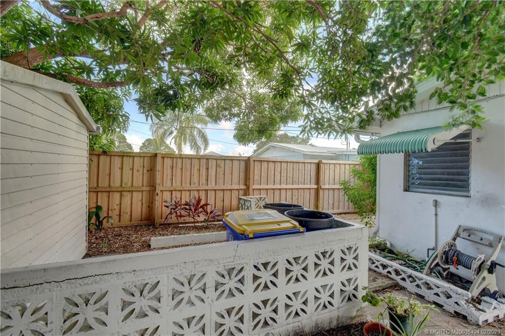 4651 Southeast Chatham Avenue Stuart, FL 34997 - Photo 29 of 49 a backyard of a house with lawn chairs and wooden fence