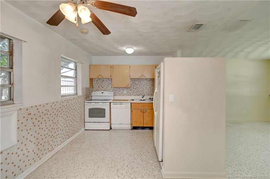 4651 Southeast Chatham Avenue Stuart, FL 34997 - Photo 42 of 49 a kitchen with a stove a sink and a refrigerator