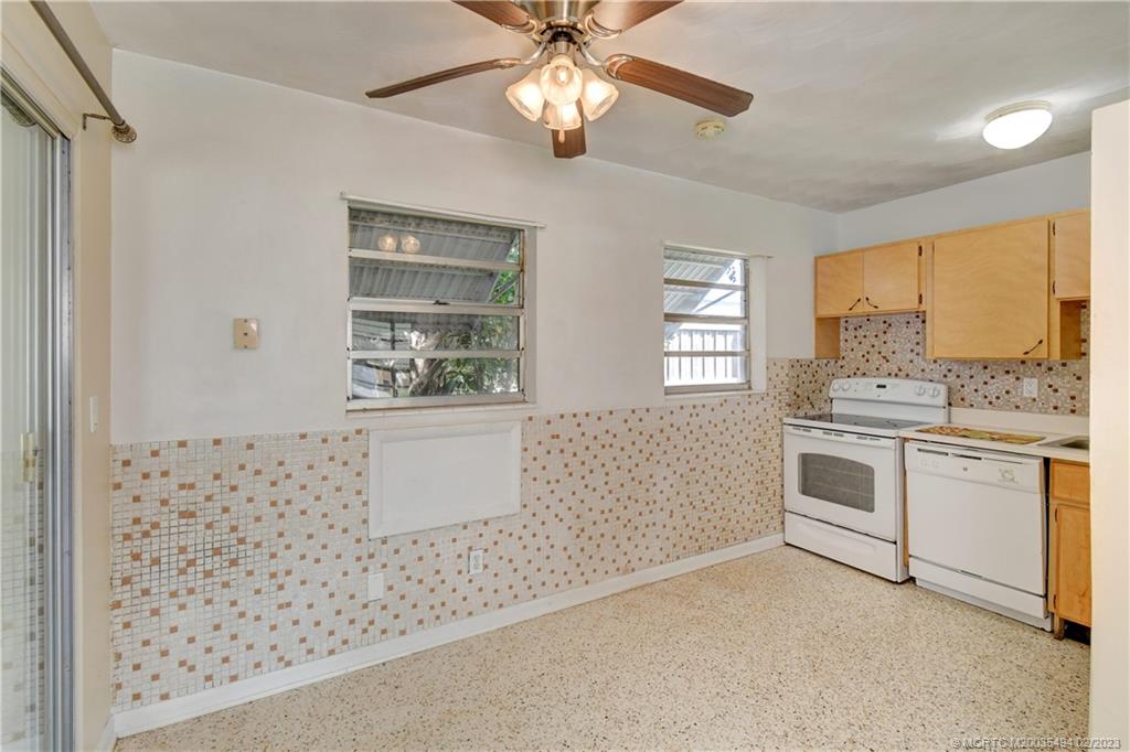 4651 Southeast Chatham Avenue Stuart, FL 34997 - Photo 45 of 49 a kitchen with granite countertop white cabinets and white appliances
