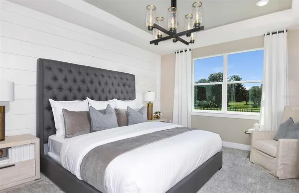 a bedroom with a large bed and a chandelier
