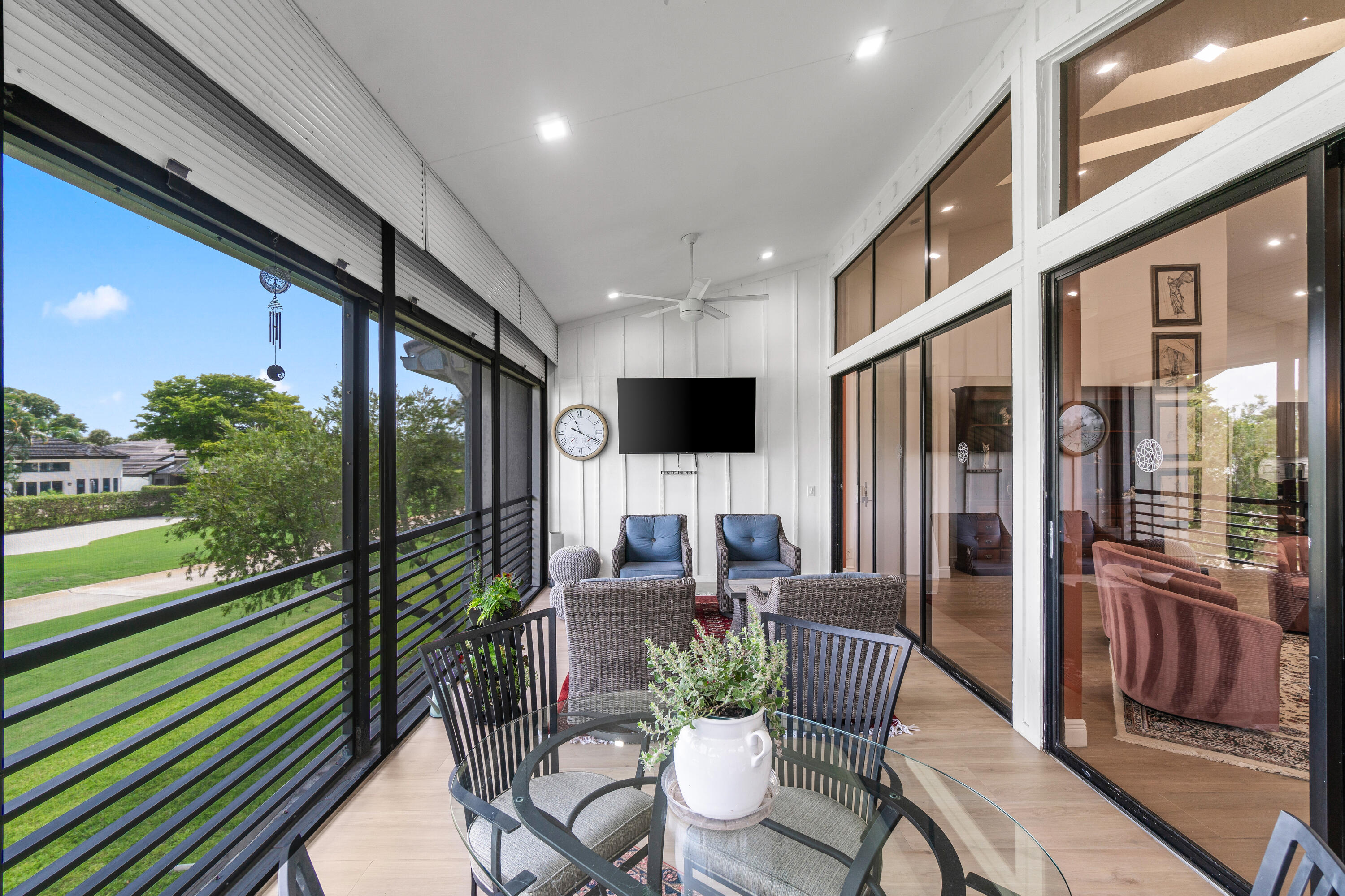 17557 Ashbourne Lane, Unit B Boca Raton, FL 33496 - Photo 16 of 41 a living room with furniture tv and a floor to ceiling window