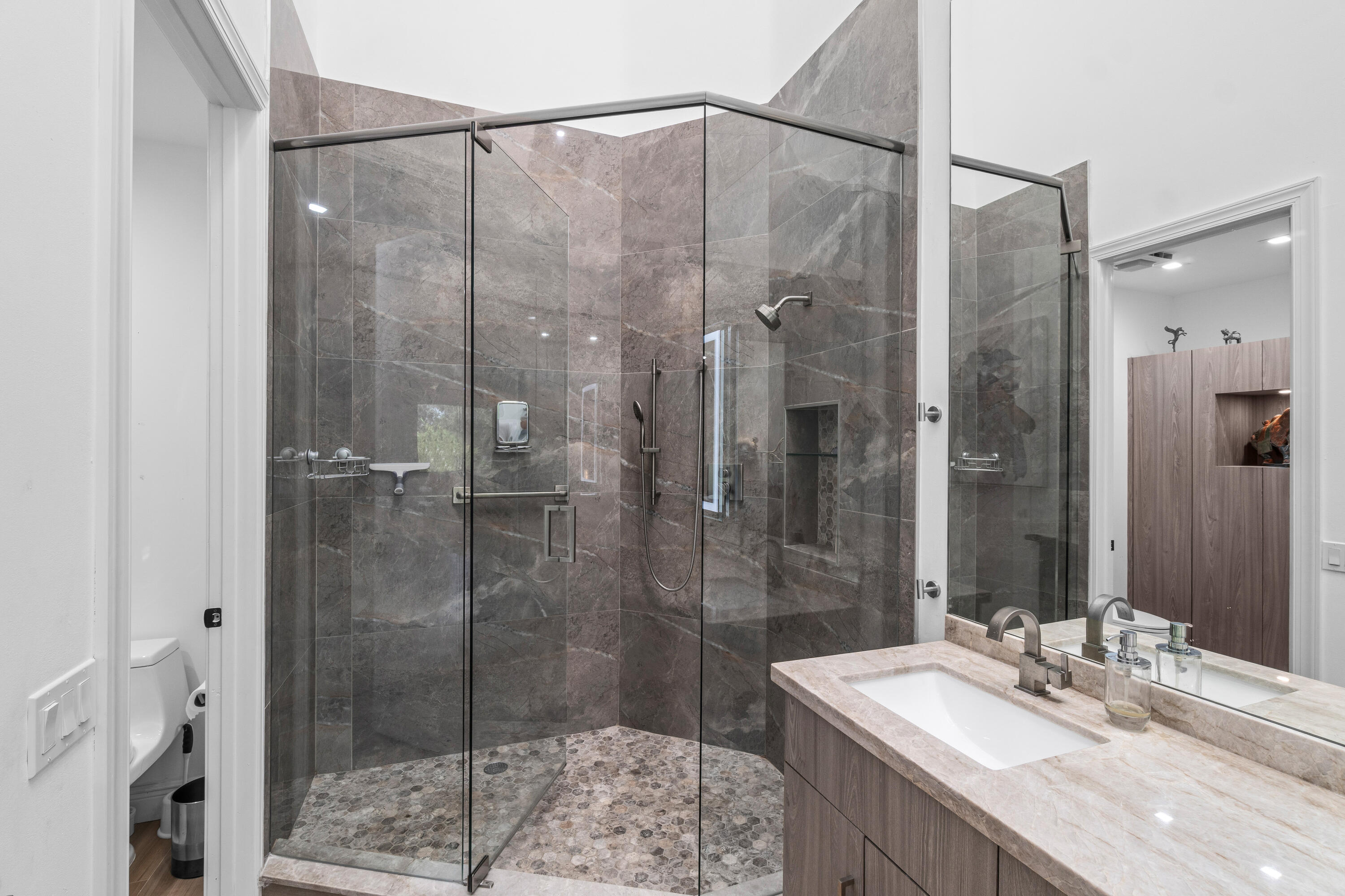 17557 Ashbourne Lane, Unit B Boca Raton, FL 33496 - Photo 23 of 41 a bathroom with a granite countertop sink a shower and a mirror