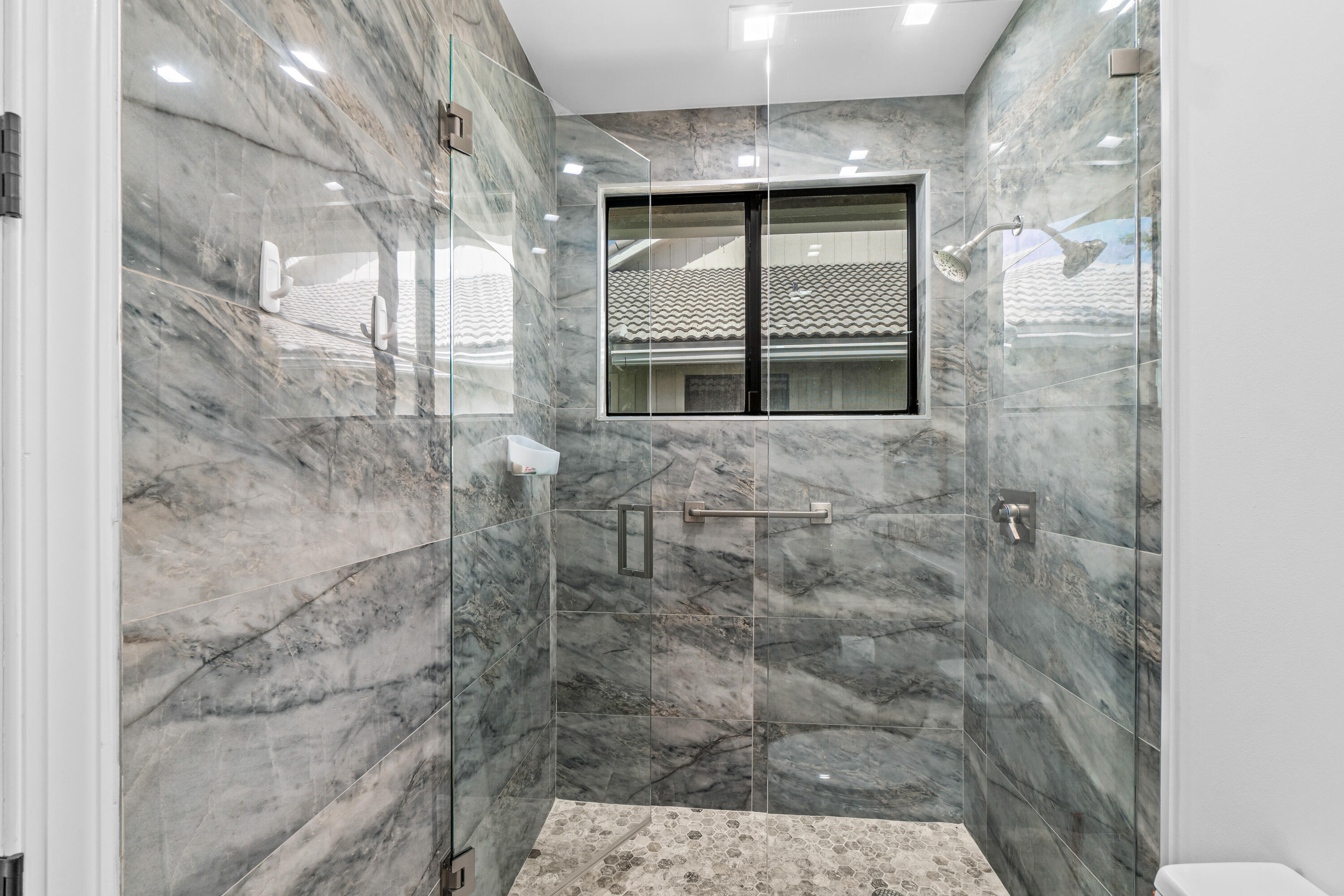 17557 Ashbourne Lane, Unit B Boca Raton, FL 33496 - Photo 28 of 41 a bathroom with a shower