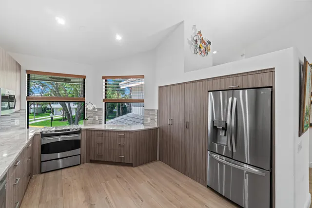 a kitchen with stainless steel appliances granite countertop a refrigerator and a sink