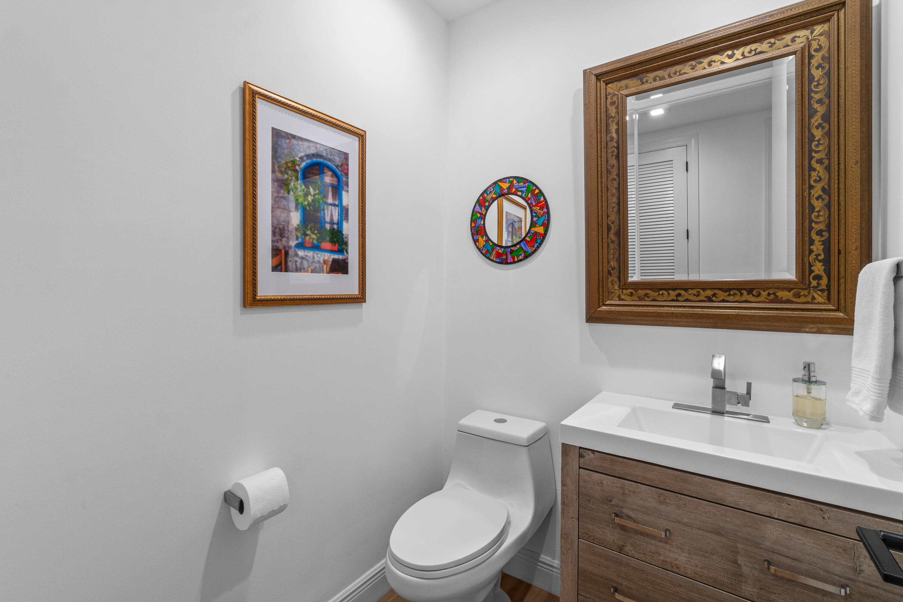 17557 Ashbourne Lane, Unit B Boca Raton, FL 33496 - Photo 31 of 41 a bathroom with a toilet sink and mirror