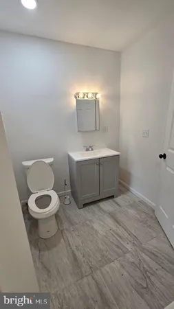 a bathroom with a toilet a sink and mirror