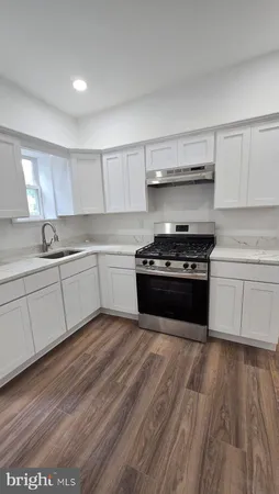 a kitchen with wooden floors and appliances