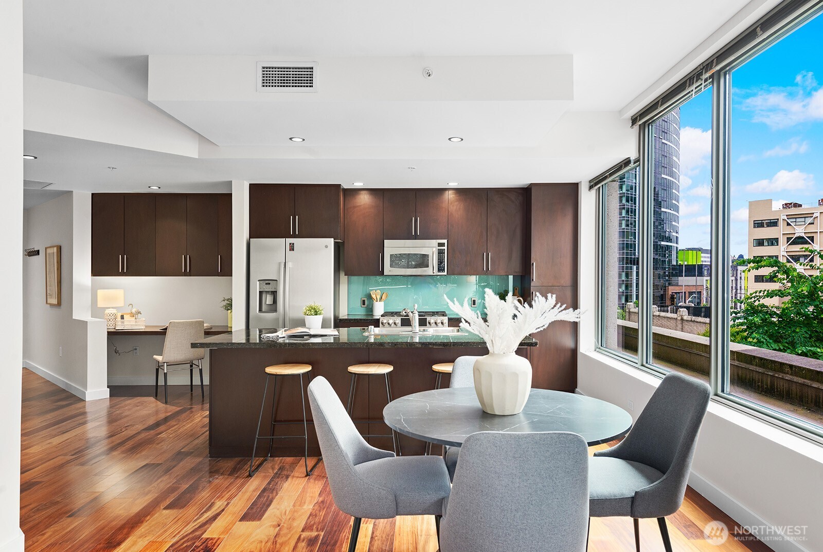 910 Lenora Street, Unit S403 Seattle, WA 98121 - Photo 12 of 40 a dining room with furniture a wooden floor and a kitchen view