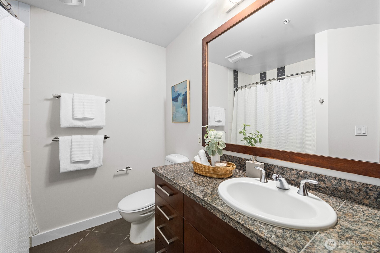 910 Lenora Street, Unit S403 Seattle, WA 98121 - Photo 19 of 40 a bathroom with a granite countertop sink a toilet and a mirror