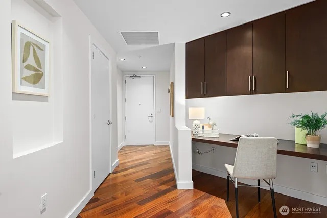 a view of a hallway to a livingroom with furniture and wooden floor