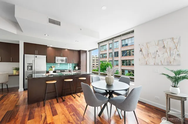 a living room with stainless steel appliances kitchen island granite countertop furniture a rug kitchen view and a large window