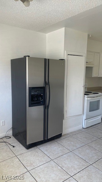 350 East Desert Inn Road, Unit B103 Las Vegas, NV 89109 - Photo 17 of 25 Kitchen featuring stainless steel refrigerator, electric range, light tile patterned flooring, white cabinets, and a textured ceiling